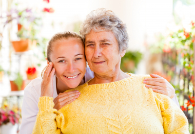 senior woman and her caregiver smiling